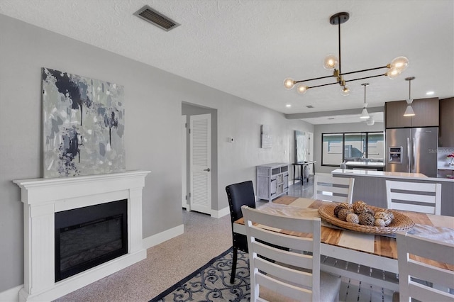 dining room with a textured ceiling and an inviting chandelier