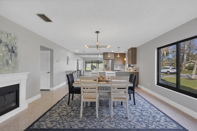 dining area with a textured ceiling and an inviting chandelier