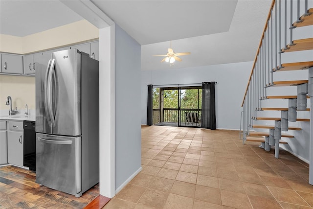 kitchen featuring stainless steel refrigerator, ceiling fan, sink, black dishwasher, and light tile patterned floors