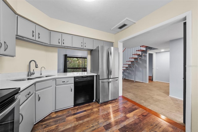 kitchen featuring gray cabinetry, dark hardwood / wood-style flooring, sink, and appliances with stainless steel finishes