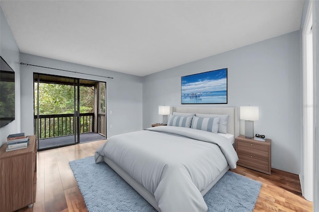 bedroom featuring access to exterior and light wood-type flooring