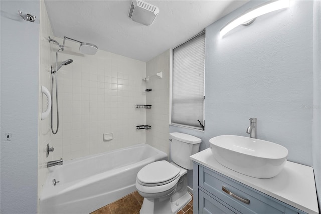 full bathroom featuring tile patterned flooring, vanity, toilet, and tiled shower / bath