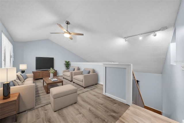 living room with track lighting, light hardwood / wood-style flooring, ceiling fan, and lofted ceiling