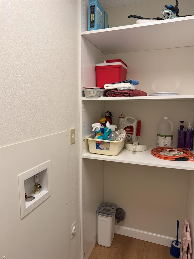 clothes washing area with hardwood / wood-style flooring and hookup for a washing machine