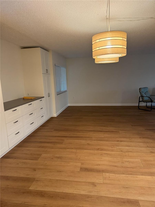 interior space featuring a textured ceiling and light wood-type flooring