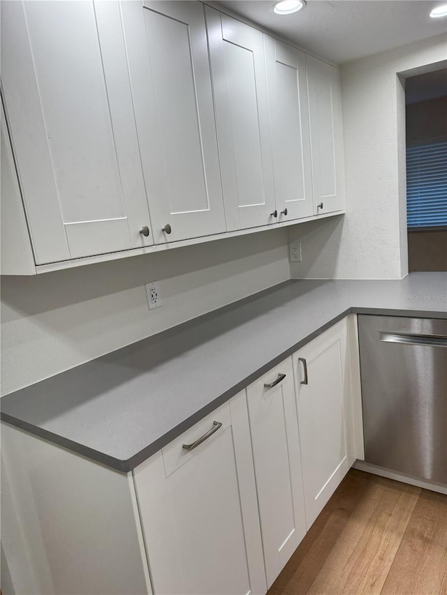 kitchen featuring white cabinets, dishwasher, and light hardwood / wood-style floors