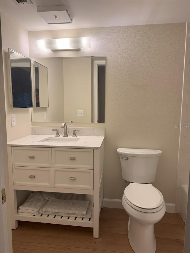 bathroom with toilet, wood-type flooring, and vanity