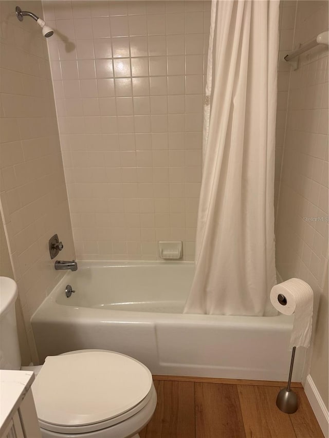 full bathroom with shower / bathtub combination with curtain, toilet, vanity, and hardwood / wood-style flooring