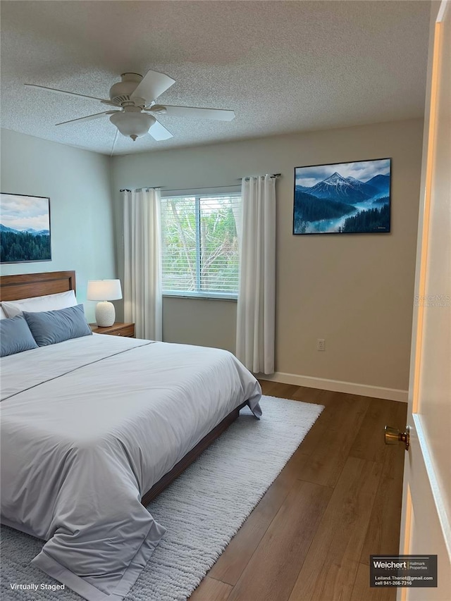 bedroom featuring a textured ceiling, ceiling fan, and dark hardwood / wood-style floors