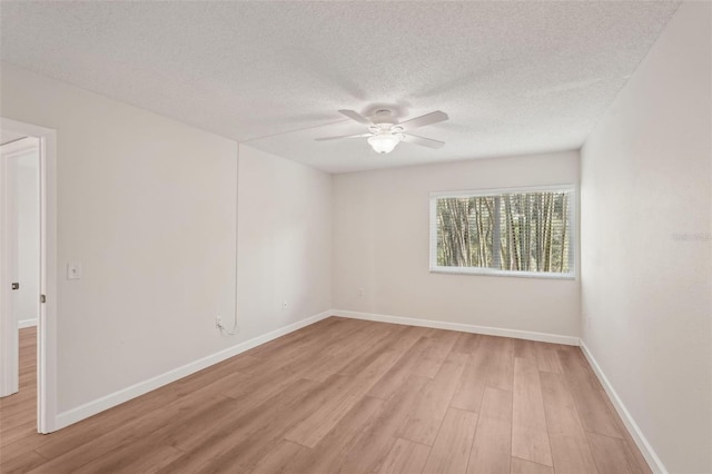 2753 Orchid Oaks Dr Unit 104, Sarasota, FL 34239 - spare room with light wood-style floors, ceiling fan, a textured ceiling, and baseboards