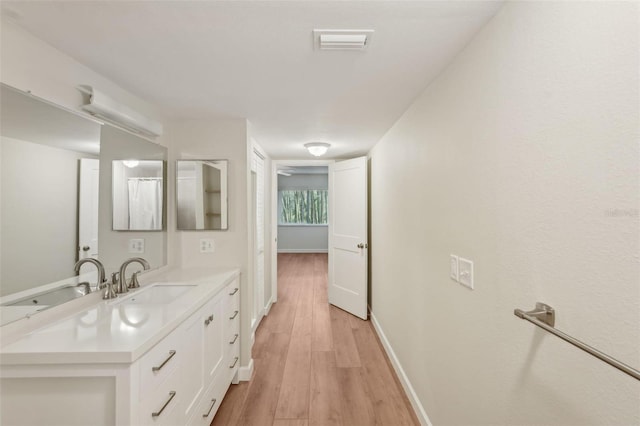 2753 Orchid Oaks Dr Unit 104, Sarasota, FL 34239 - bathroom with vanity, wood finished floors, and baseboards