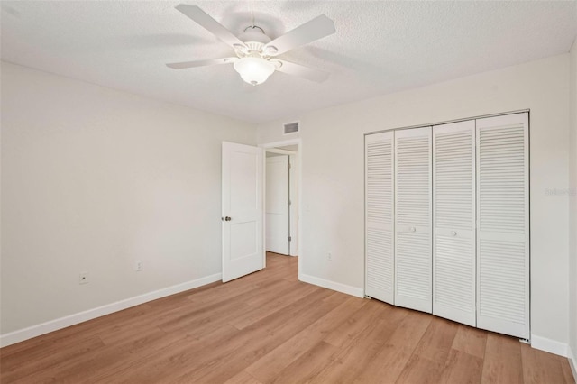 2753 Orchid Oaks Dr Unit 104, Sarasota, FL 34239 - unfurnished bedroom with light wood finished floors, baseboards, a closet, ceiling fan, and a textured ceiling