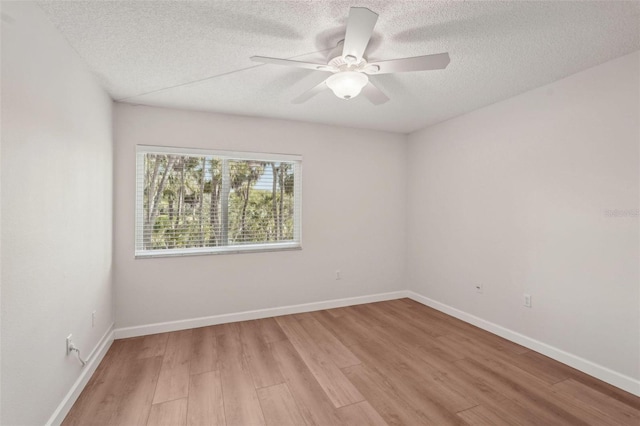2753 Orchid Oaks Dr Unit 104, Sarasota, FL 34239 - spare room with light wood-style floors, a textured ceiling, a ceiling fan, and baseboards