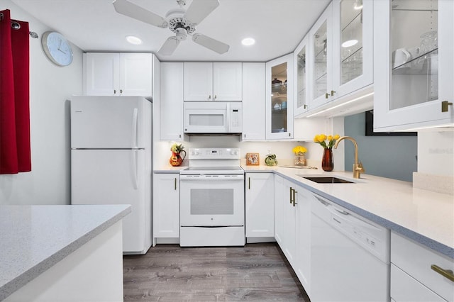 kitchen with sink, white cabinets, dark wood-type flooring, and white appliances