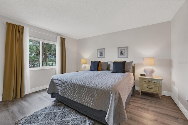 bedroom with wood-type flooring and a textured ceiling