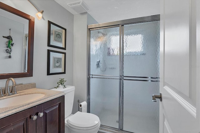 bathroom with vanity, toilet, and a shower with shower door