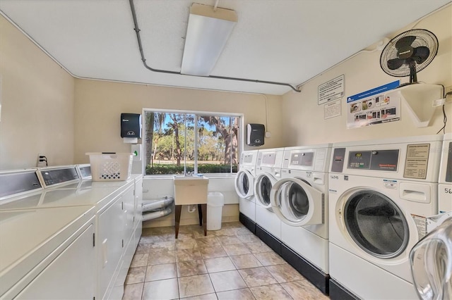 laundry room with washer and clothes dryer and light tile patterned flooring