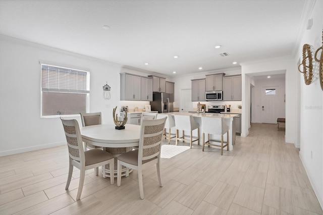 dining space with crown molding and sink