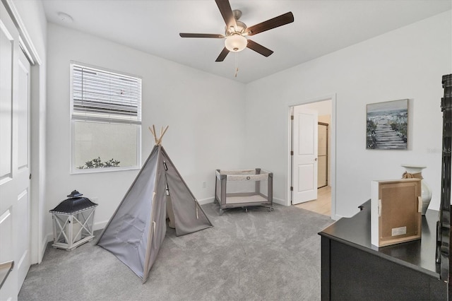 recreation room featuring light carpet and ceiling fan