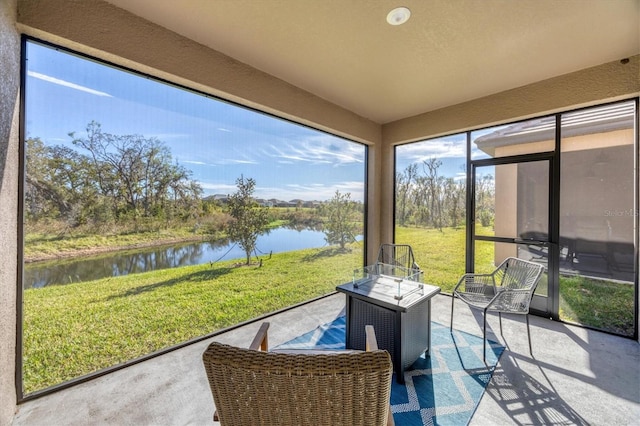 sunroom / solarium featuring a water view