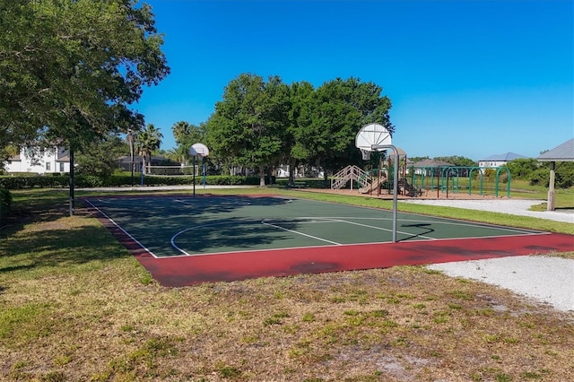 view of basketball court with a playground and a lawn