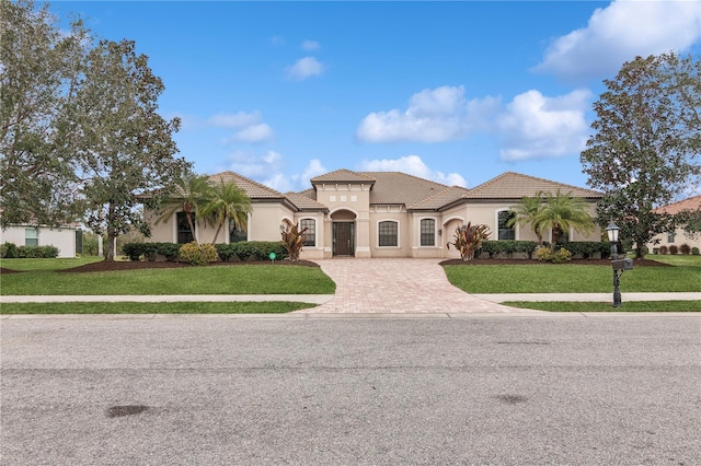 mediterranean / spanish house featuring a front yard