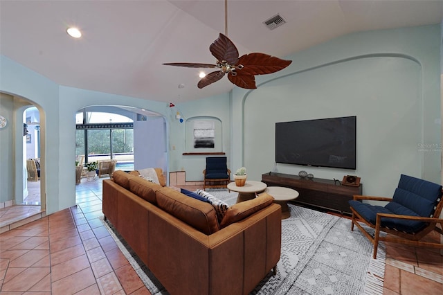 tiled living room featuring ceiling fan and vaulted ceiling