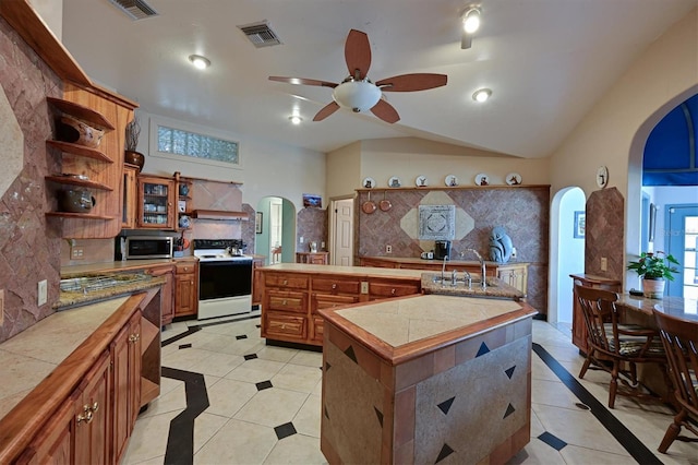 kitchen featuring tile counters, a center island, light tile patterned floors, decorative backsplash, and white electric stove