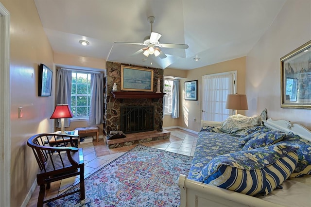 tiled living room with ceiling fan and a fireplace