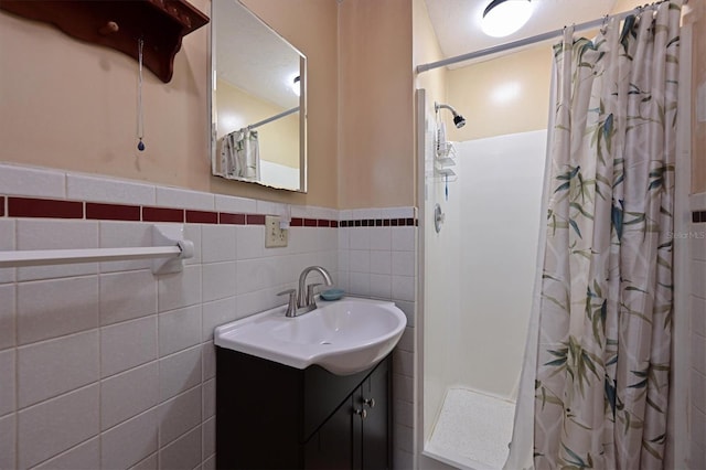 bathroom featuring tile walls, curtained shower, and vanity