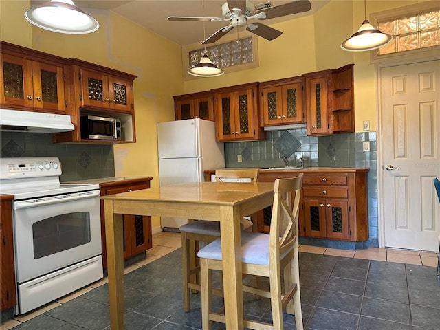 kitchen featuring white appliances, pendant lighting, dark tile patterned flooring, decorative backsplash, and sink