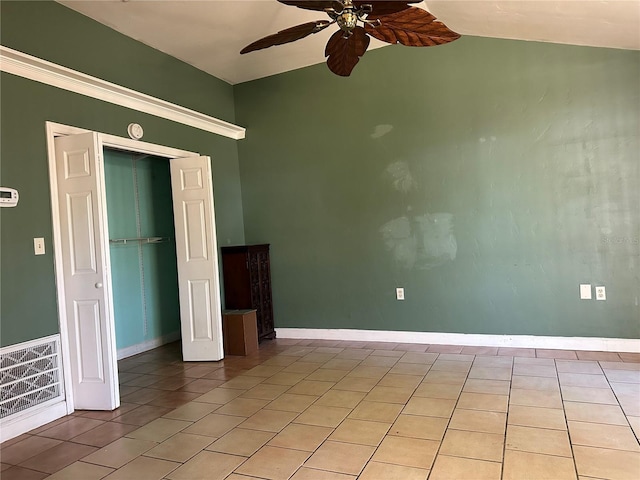 interior space featuring ceiling fan, vaulted ceiling, and light tile patterned floors