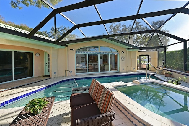 view of swimming pool featuring glass enclosure, an in ground hot tub, and a patio area