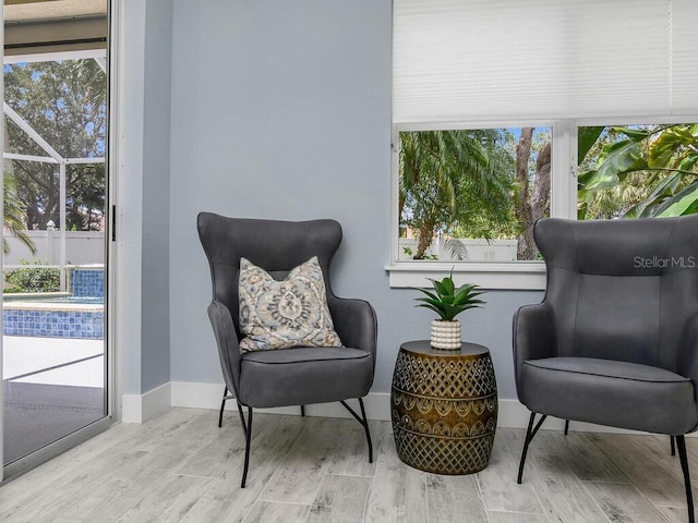 living area featuring baseboards and light wood finished floors