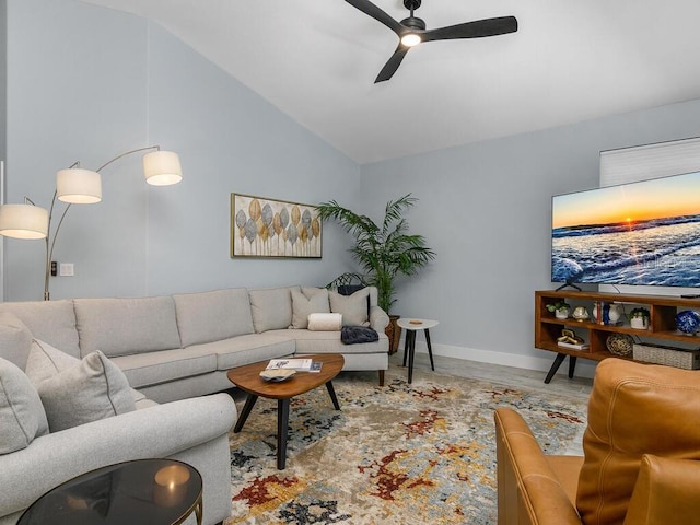 living room featuring lofted ceiling, baseboards, a ceiling fan, and light wood-style floors