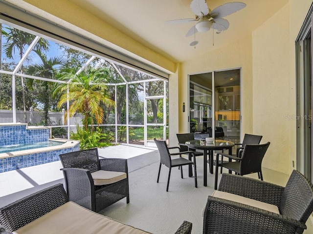 view of patio / terrace featuring glass enclosure, fence, an outdoor pool, and a ceiling fan