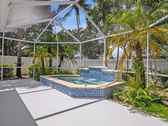 view of patio featuring a fenced backyard, a lanai, and a hot tub