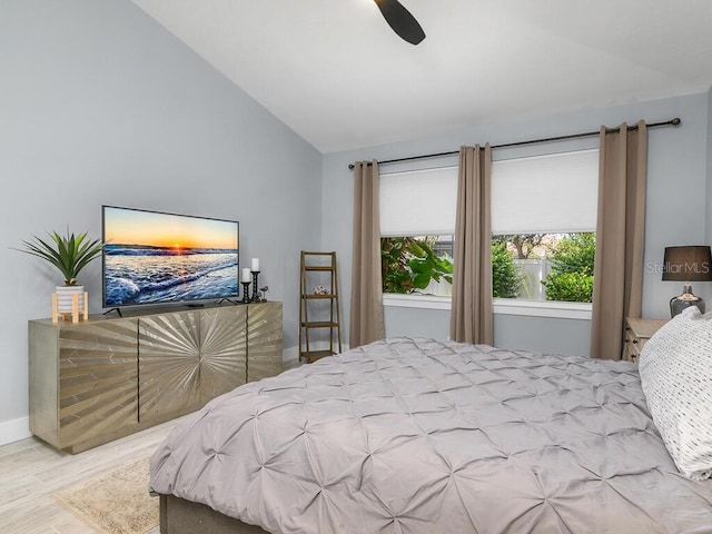 bedroom with a ceiling fan, lofted ceiling, light wood-style flooring, and baseboards