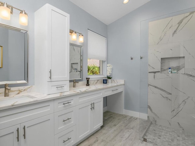 full bath with double vanity, a sink, and a marble finish shower