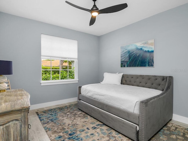 bedroom with wood finished floors, a ceiling fan, and baseboards