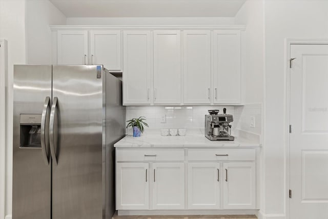 kitchen featuring decorative backsplash, white cabinetry, and stainless steel fridge with ice dispenser