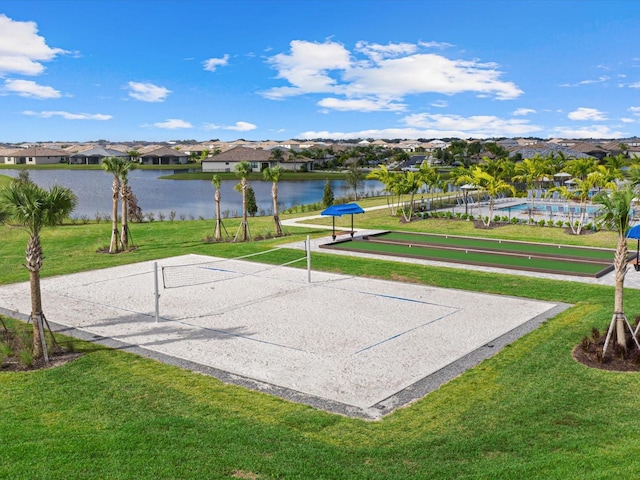 surrounding community with a lawn, volleyball court, and a water view