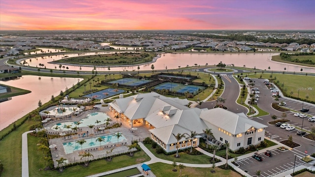 aerial view at dusk featuring a water view