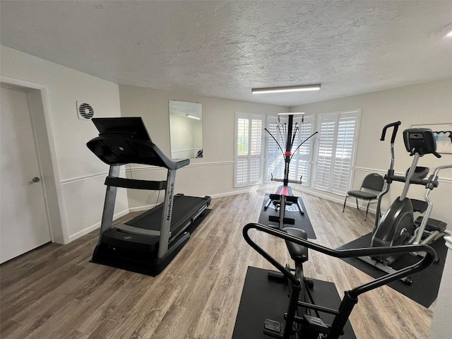 workout area featuring a textured ceiling and hardwood / wood-style flooring