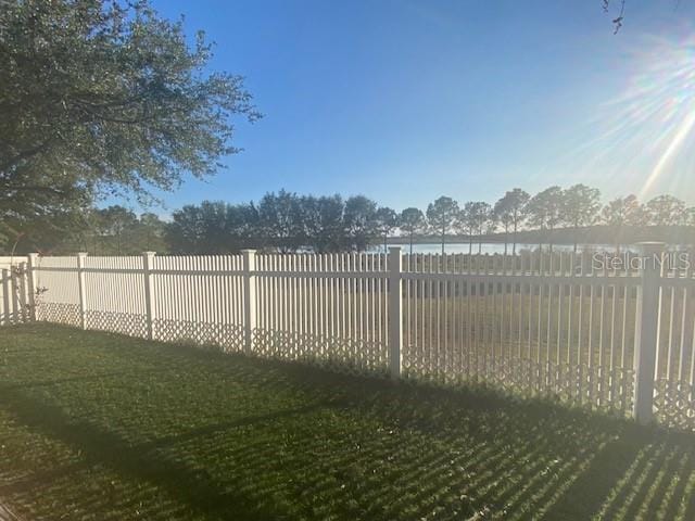 view of gate with a lawn and a water view