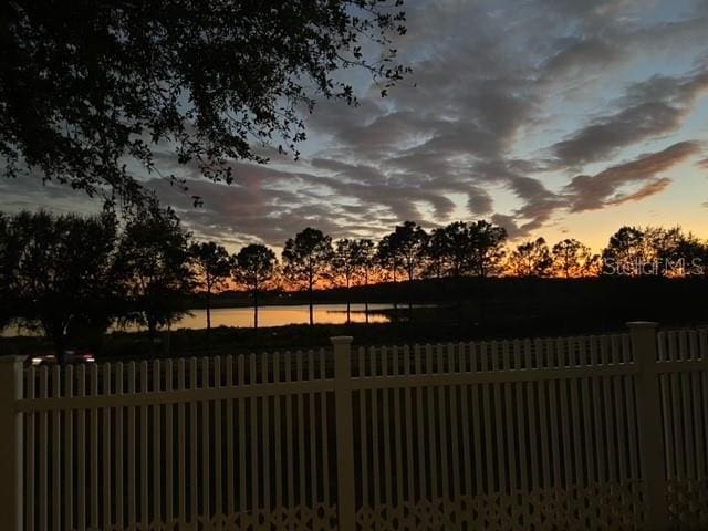 gate at dusk featuring a water view