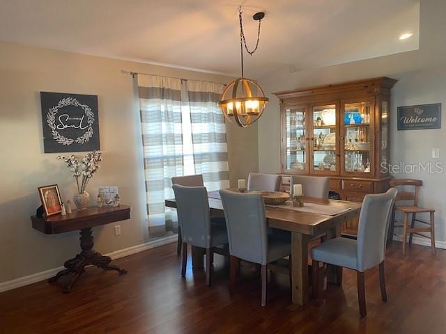 dining area featuring dark hardwood / wood-style floors and a chandelier