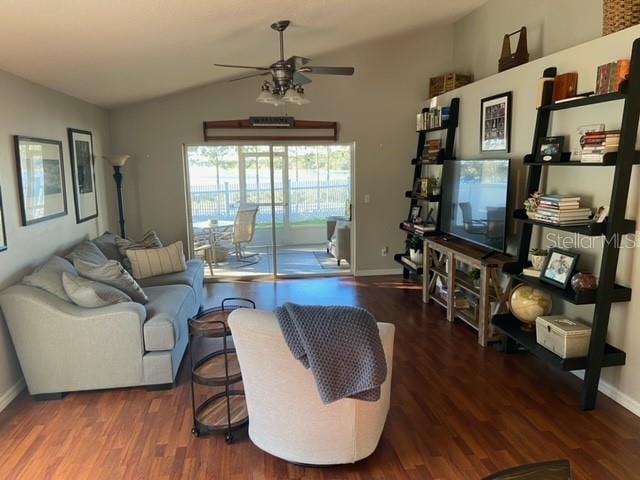 living room featuring vaulted ceiling, dark hardwood / wood-style floors, and ceiling fan