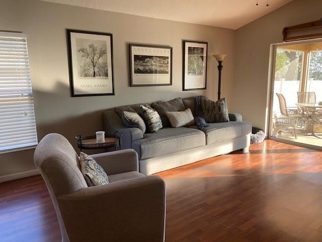 living room with lofted ceiling and dark hardwood / wood-style flooring