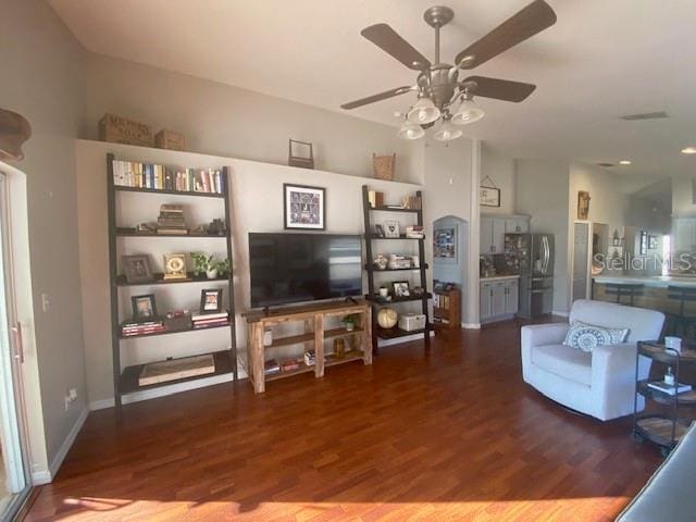 living room featuring lofted ceiling, dark wood-type flooring, and ceiling fan